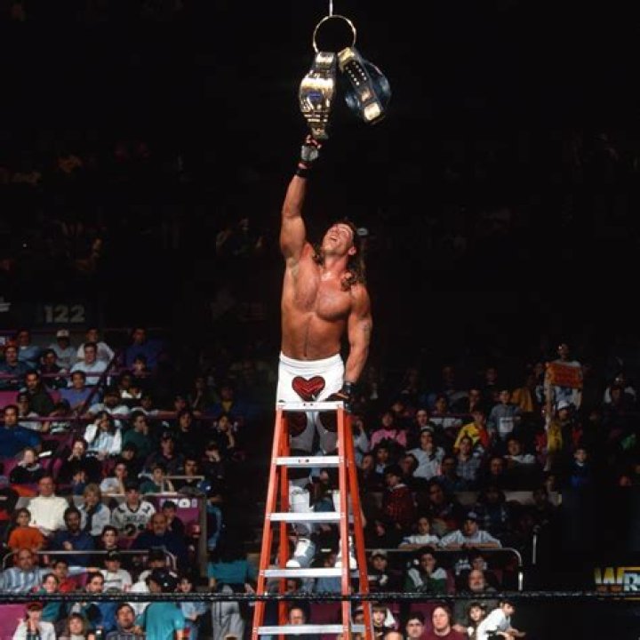 a man holding a wrestling belt in his right hand