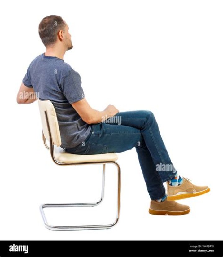 a man sitting on a chair holding a cello